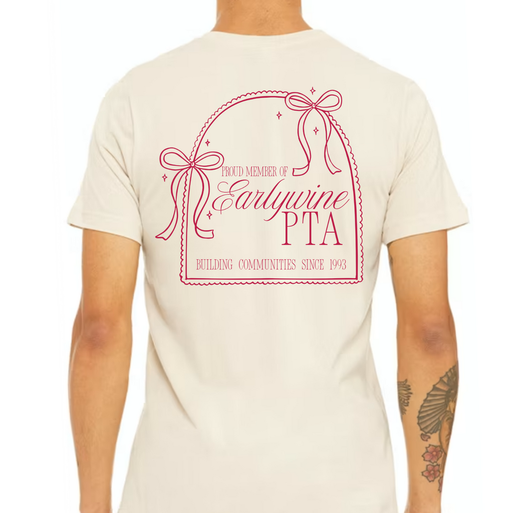 Back view of a cream-colored t-shirt featuring a large pink bow-inspired Community Bow design with customizable organization, member, and leadership text.